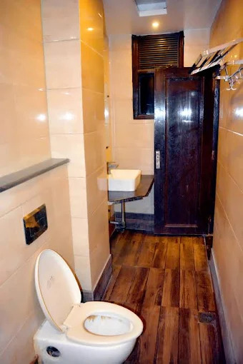 Clean private bathroom with warm-tone tiles at Delhi Empire DX, Hotel in Paharganj