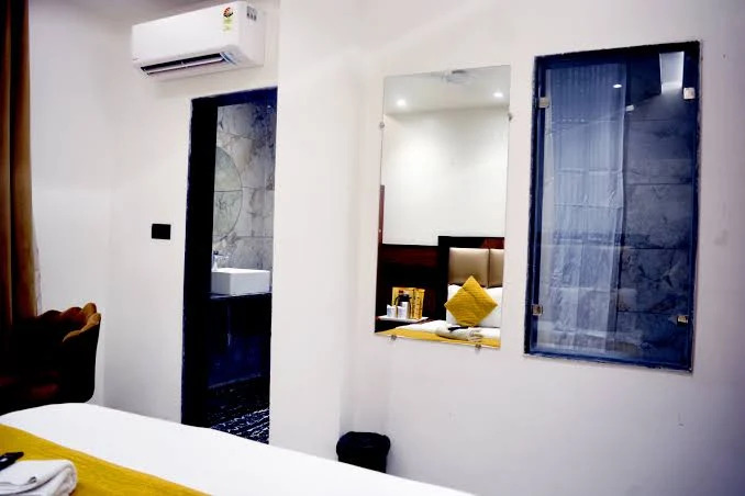 Delhi Empire DX Room — modern guest room with mirror, AC and ensuite bathroom view
